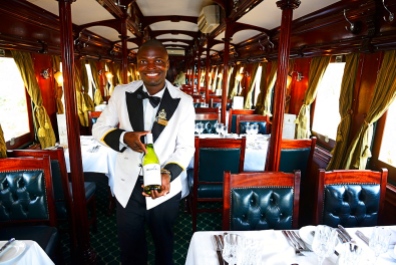 Service staff with wine selection in luxury train, Royal Livingstone Express, Livingstone, Zambia, Africa